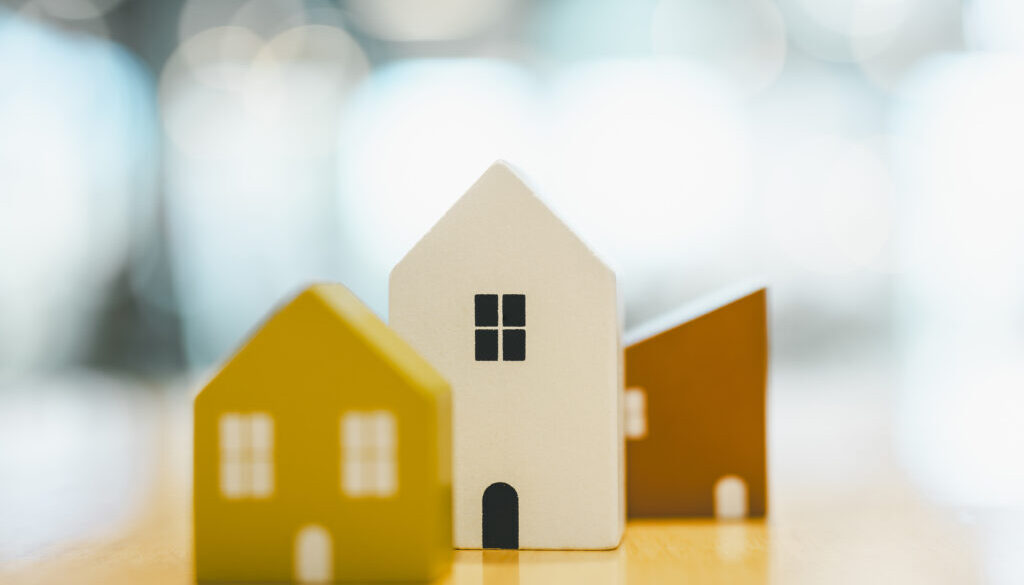 Wooden house model on wood background, a symbol for construction , ecology, loan, mortgage, property or home.