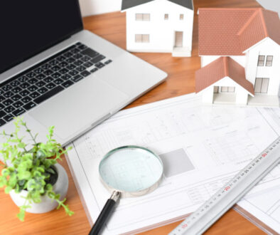 Architectural models, architectural drawings, and laptop computers lined up on the desk